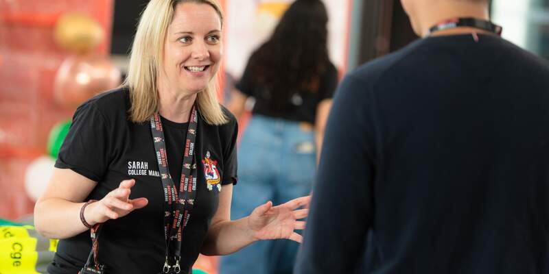 A member of the College team greets a new student